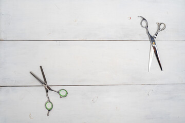 scissors on the desktop of a beauty salon on a white wooden background, top view space for text