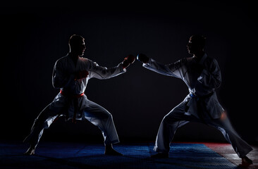 The karate guys in white kimono and belt training karate