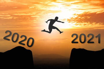 2021 New year concept : Silhouette man jumping from year 2020 to new year 2021