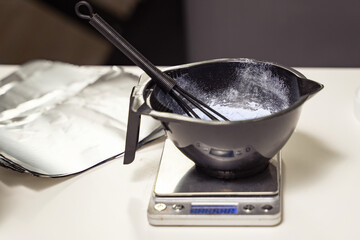 White hair dye in container on the special table in hair salon