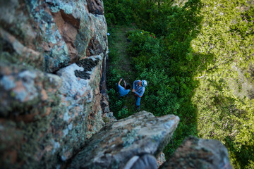 Two men putting on their harness and rock climbing equipment