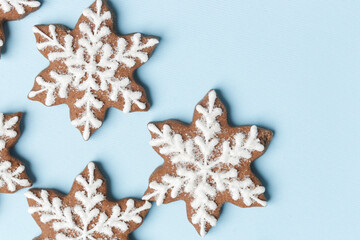Star shaped gingerbread cookies on light blue wintery background.