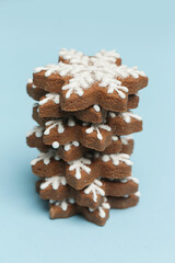 Star shaped gingerbread cookies on light blue wintery background.