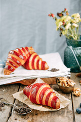 Delicious Golden croissants with strawberry marmalade. Jam-glazed croissants in close-up.