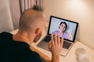Man facetime at home, calling his friend wife girlfriend from laptop in bedroom. 