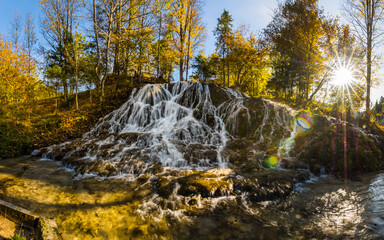 large waterfall and colorfu autumn forest panorama