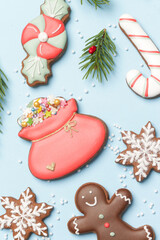 Beautiflly decorated gingerbread cookies on wintery blue background. Tasty homemade Christmas cookies close up view. 
