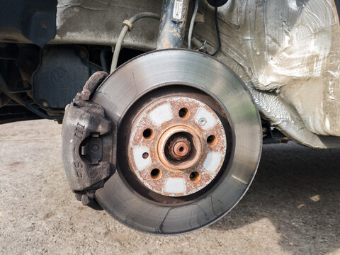 Brake disc system, pads and shield of vehicle without wheels for repair or replacement close up, suspension of car, process of new tire replacement, service concept, maintain rusty car parts