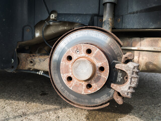 Brake disc system, pads and shield of vehicle without wheels for repair or replacement close up, suspension of car, process of new tire replacement, service concept, maintain rusty car parts