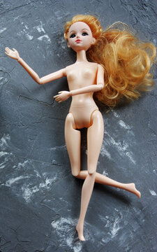 plastic doll on grey background