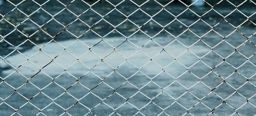 A texture and background of a vintage steel net fence.