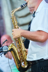 Fototapeta premium Musical instrument saxophone in the hands of the artist.