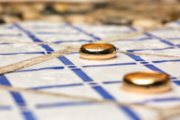 pair of wedding rings over decorated tiles