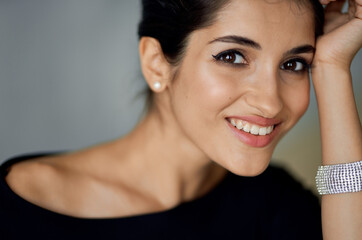 portrait of sexy brunette with bracelet on gray background evening dress model