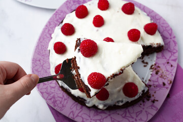 Delicious chocolate cake with cheese cream on top and raspberries. Christmas cake. Selective focus. Copy space.