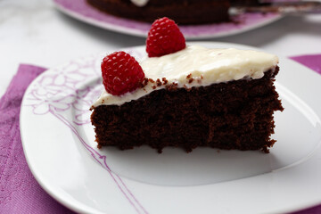 Delicious chocolate cake with cheese cream on top and raspberries. Christmas cake. Selective focus. Copy space.