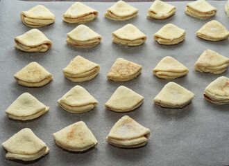 Homemade cakes on a baking sheet. homemade cookies in the form of triangles before baking.