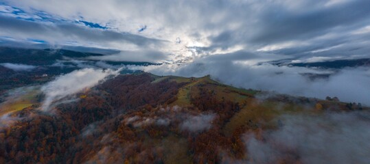 Flight through blue sky with clouds over mountain