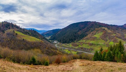 Fly over landscapes of green hills under a layer of white and fluffy clouds