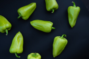Sweet green peppers on black background
