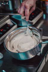 Chef hand preparing cream sauce in pan