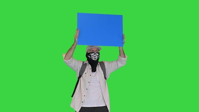 Radical protesting person with sign in his hands on a Green Screen, Chroma Key.