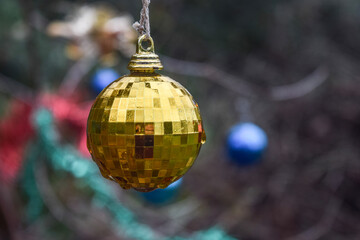Gold christmas ball facet on a tree