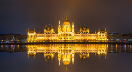 Fototapeta na wymiar Hungarian Parliament with reflection viewed at night on the Danube river in Budapest