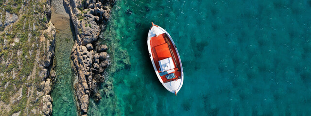 Aerial drone ultra wide top view photo of wooden traditional fishing boat in turquoise sea shore of Zakynthos island, Ionian, Greece