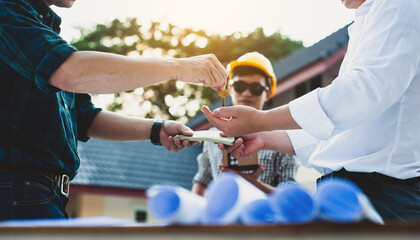 The contractor delivers the house keys and receives the wages after completing the housing project.