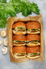 Delicious homemade burgers with beef or chicken cutlet, cheese, lettuce and fried mushrooms on sesame buns. Selective focus, top view