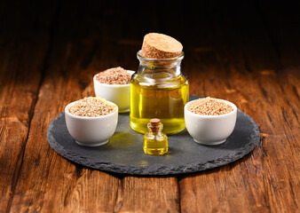 Sesame oil, sesame seeds and mustard seeds on the slate plate.