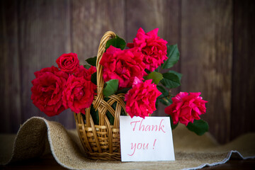 bouquet of beautiful red roses in a basket on table