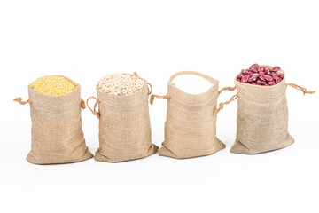 studio lighting. Retro style wooden background. There are cereals on it. Red beans, millet, pearl barley, sugar and a spice spoon next to it. Close-up