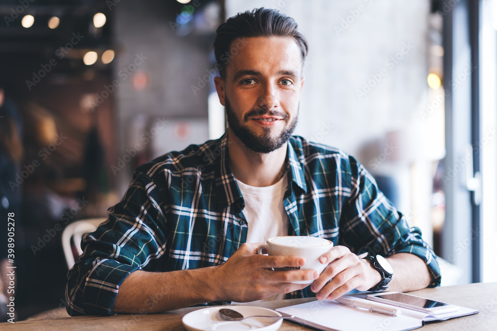 Aufkleber portrait of happy male writer with textbook smiling at camera spending daytime for creating idea in 
