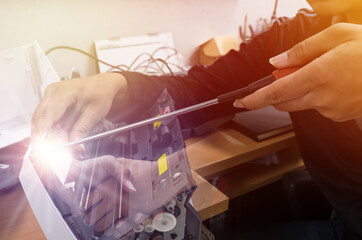 Fototapeta premium It support service, repair, maintenance and people concept - mechanic man with wrench and lamp working at workshop,Concept of repairing, upgrade, service, electronics and technology of computer.