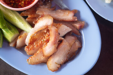 Tasty slice grilled pork served with spicy dipping sauce and vegetable side.