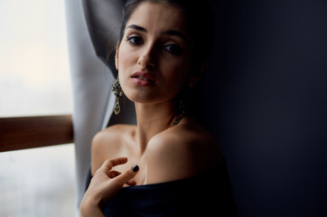Naklejka premium sexy woman near window makeup on gray curtains model evening dress