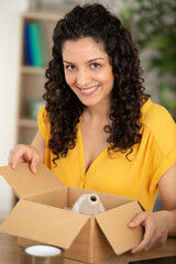 beautiful woman unpacking a carton box