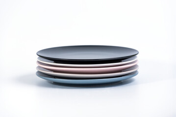 Stack of five colorful empty plates isolated on white background, side view. Navy Blue, Grey Pink, White and Black empty plates collection