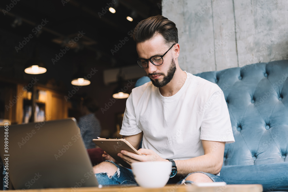 Poster caucasian male student reading informative notes during time for knowledge studying and exam prepara