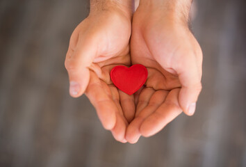 Top view of decorative red heart in man hands ,Valentines day concept, romantic concept, world health day concept.Love