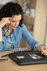 young woman fix pc components in classroom