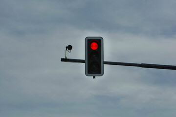 red traffic light on cloudy sky