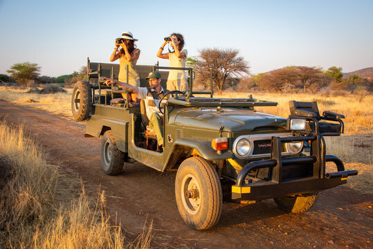 Brunettes use camera and binoculars with guide