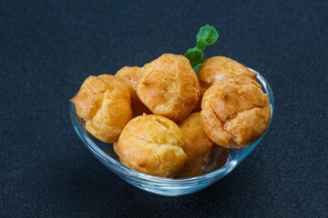 Sweet tasty profiteroles heap in the bowl