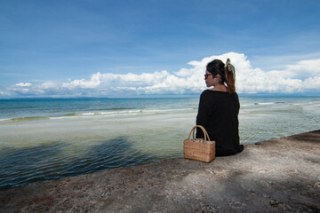 Thai girl sitting alone on the beach