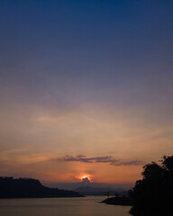 the sun sets over the lake