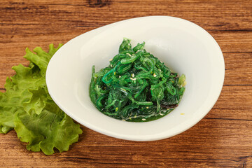 Obraz na płótnie Canvas Green Chuka Seaweed Salad Isolated on White Background Top View. Wakame Sea Kelp Salat