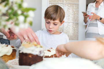 Cheerful boy in white clothes cooking pie on white background